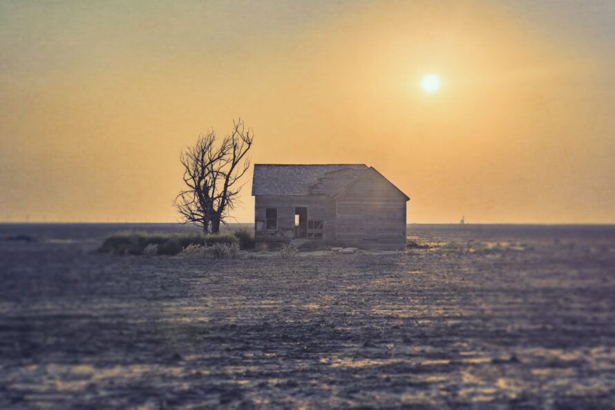 An abandoned farm sits quietly as the sunset gives off a hazy feels in Texas County Oklahoma